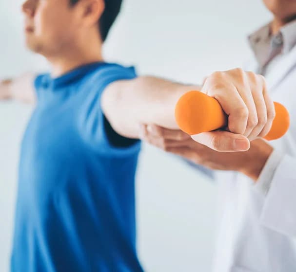 Physical therapist supporting a patient during a shoulder exercise